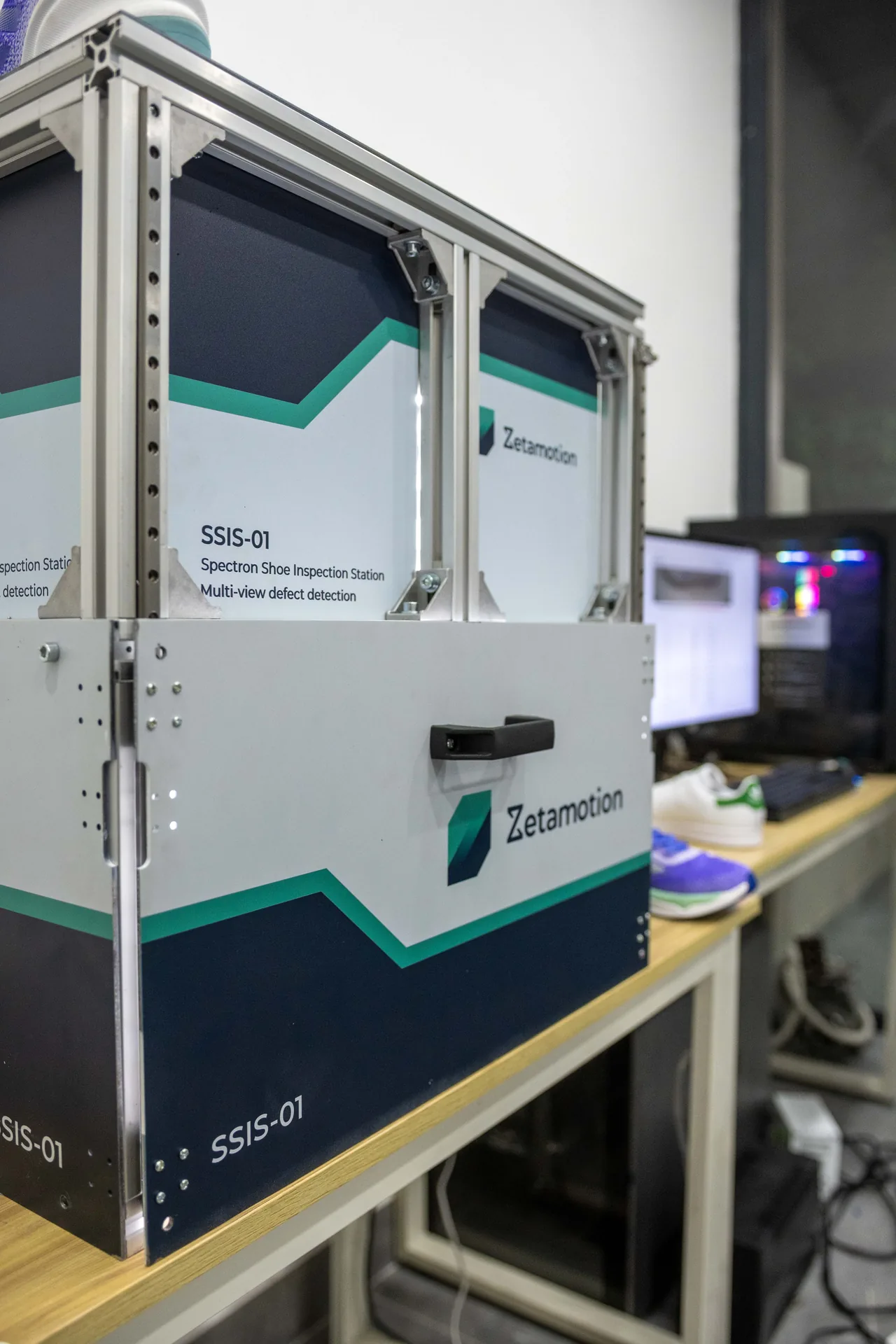 SSIS-01 Zetamotion shoe inspection station with aluminum frame and teal accents, used for multi-view defect detection on a workbench.
